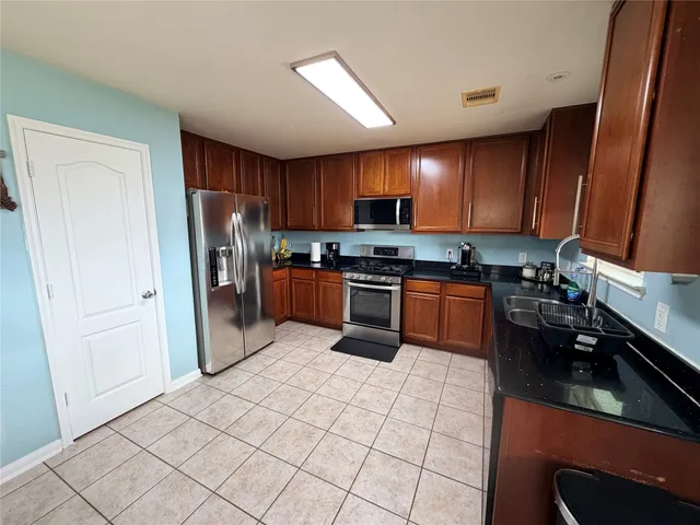 a kitchen with stainless steel appliances a refrigerator sink stove microwave and cabinets