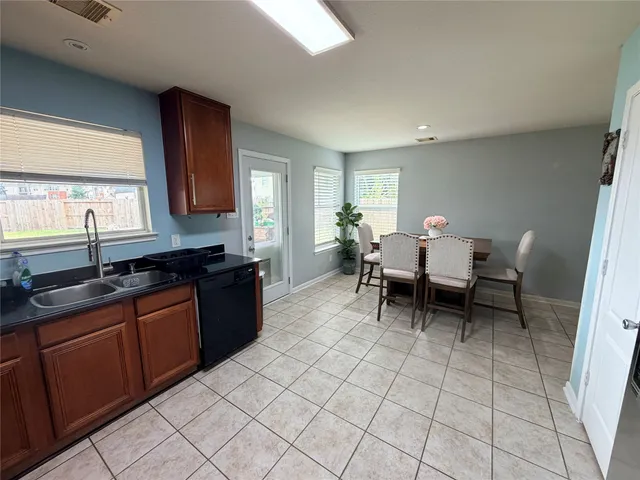 a kitchen with a sink dining table and chairs