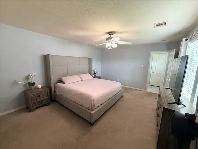 a bedroom with a bed dresser and a chandelier