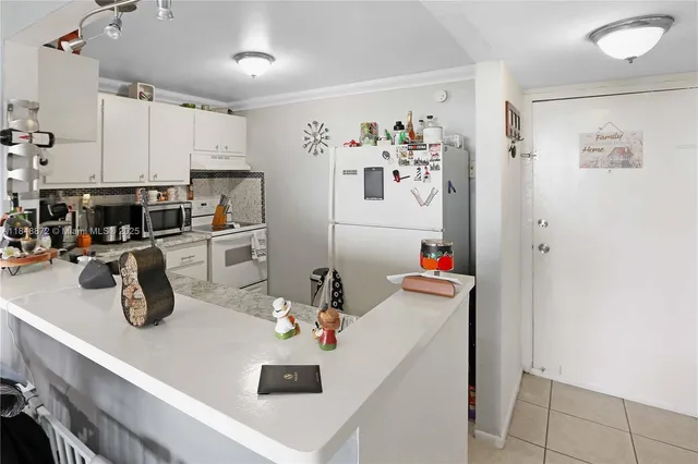 a kitchen with a sink dishwasher stove and white cabinets with wooden floor