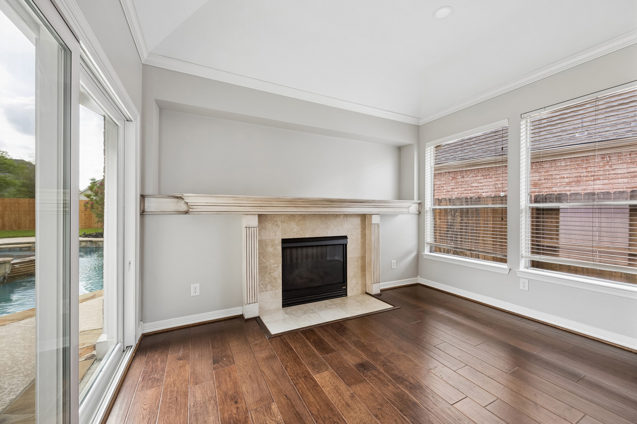 6331 Collina Springs Court Houston, TX 77041 - Photo 16 of 34 a view of an empty room with wooden floor fireplace and a window