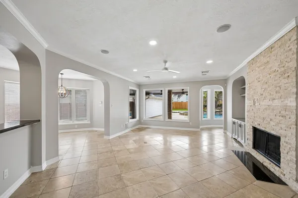 a view of an empty room with wooden floor fireplace and a window