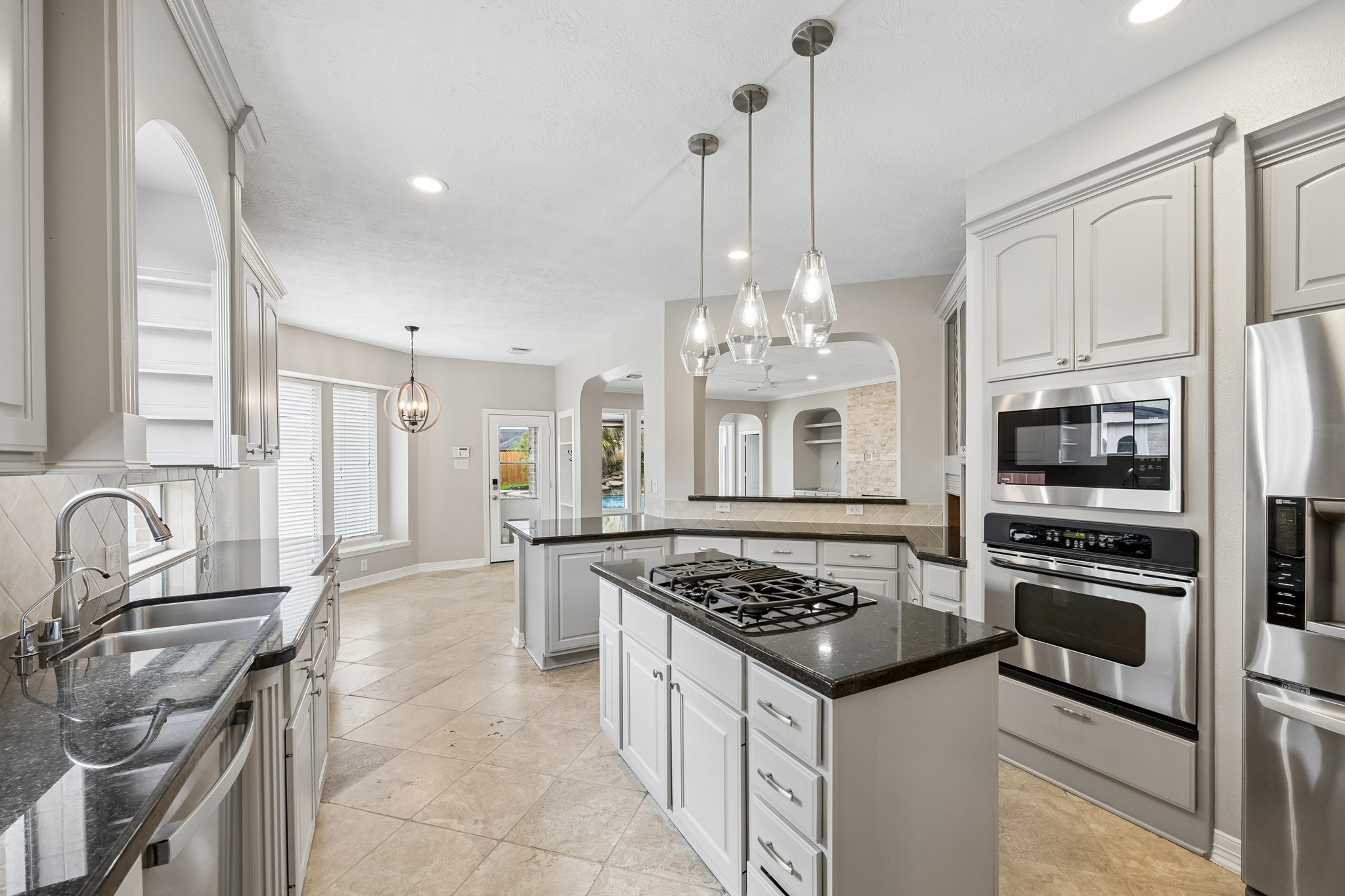 6331 Collina Springs Court Houston, TX 77041 - Photo 10 of 34 a kitchen with granite countertop a sink stove and refrigerator