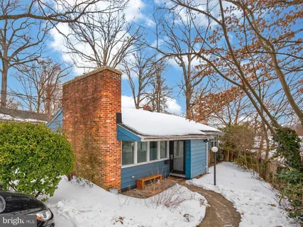 a front view of a house with a yard covered with snow