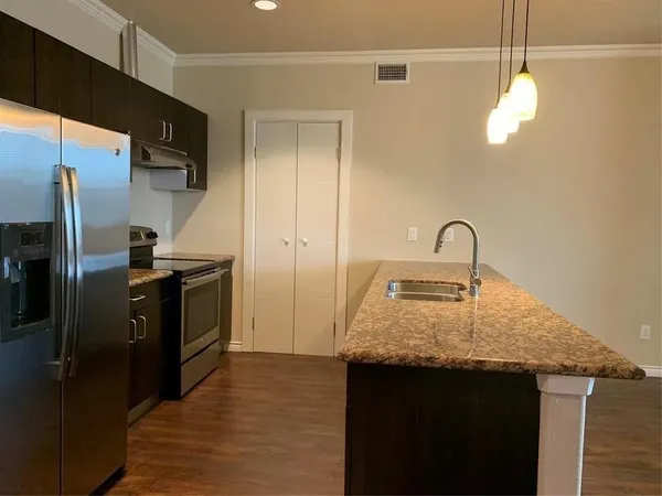 a kitchen with a sink a refrigerator and cabinets