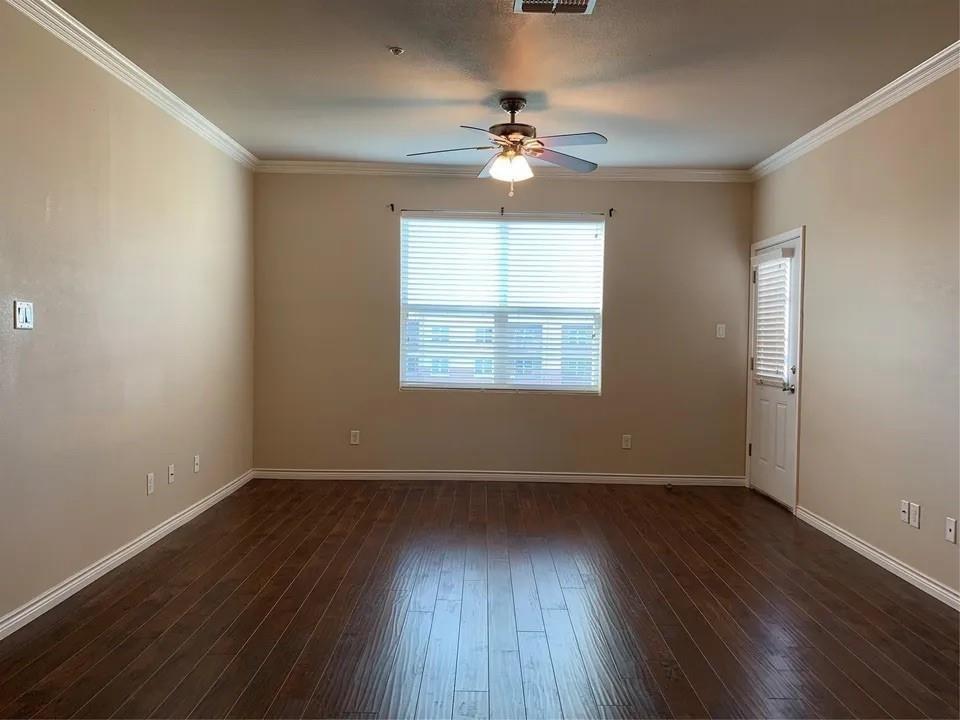 1100 West Trinity Mills Road, Unit 2025 Carrollton, TX 75006 - Photo 6 of 16 a view of an empty room with wooden floor and a window