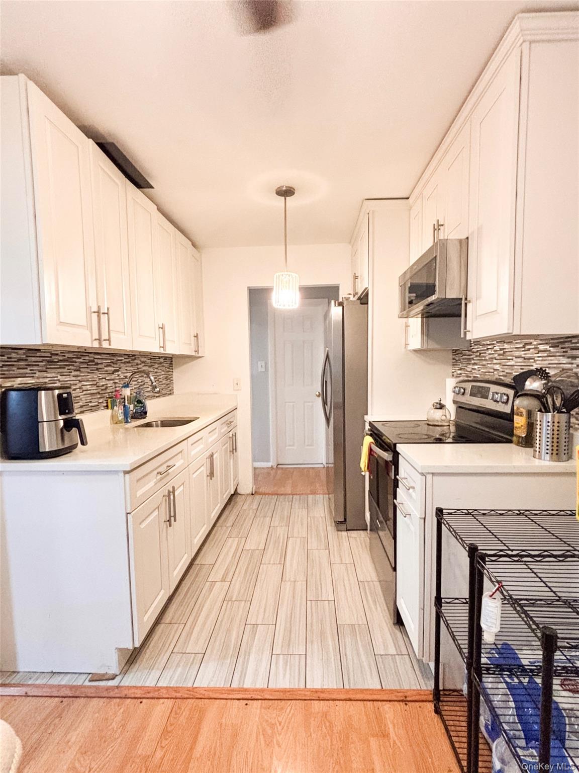 a kitchen with a sink a refrigerator a stove top oven and cabinets