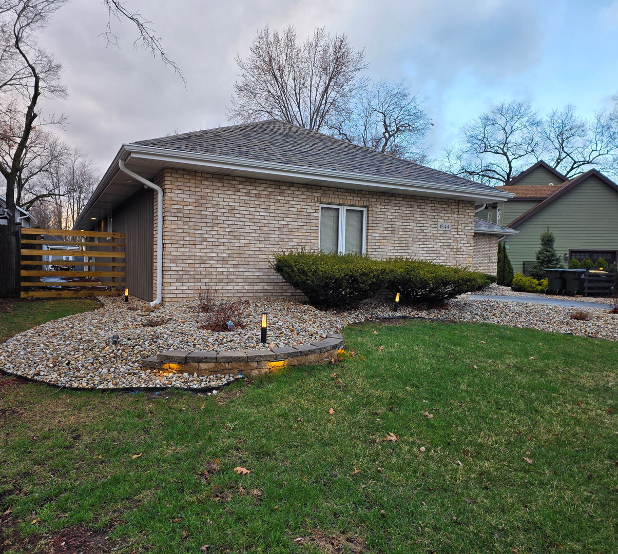 1844 180th Place Lansing, IL 60438 - Photo 2 of 34 a front view of a house with a garden