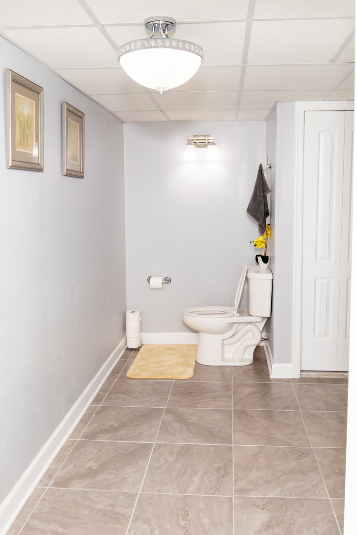 1844 180th Place Lansing, IL 60438 - Photo 27 of 34 a bathroom with a toilet a sink and mirror