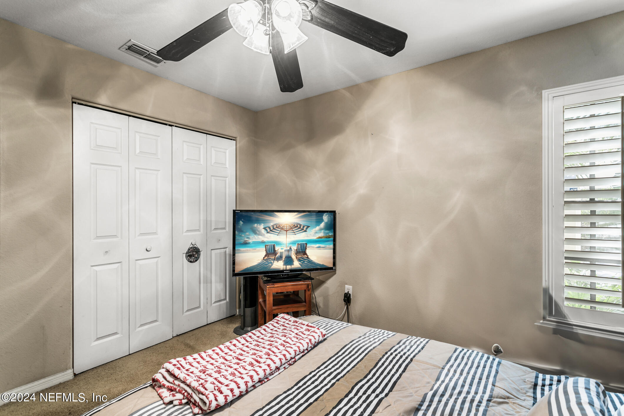 10150 Belle Rive Boulevard, Unit 2605 Jacksonville, FL 32256 - Photo 21 of 52 a bedroom with a bed and a chandelier