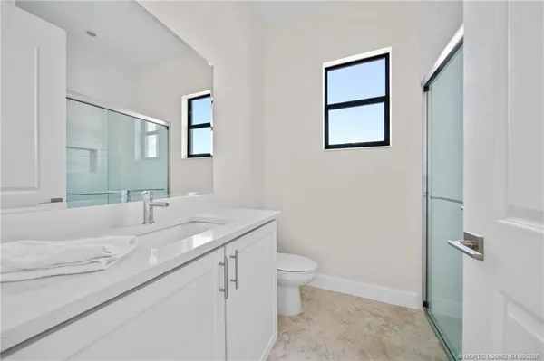 a bathroom with a granite countertop sink toilet and mirror