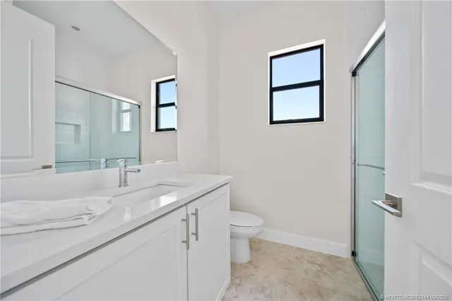a bathroom with a granite countertop sink toilet and mirror