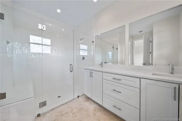 a spacious bathroom with a shower sink and mirror