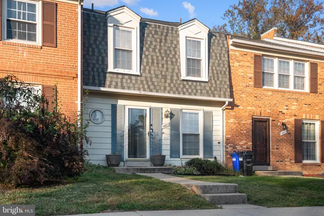 a front view of a brick house many windows and yard