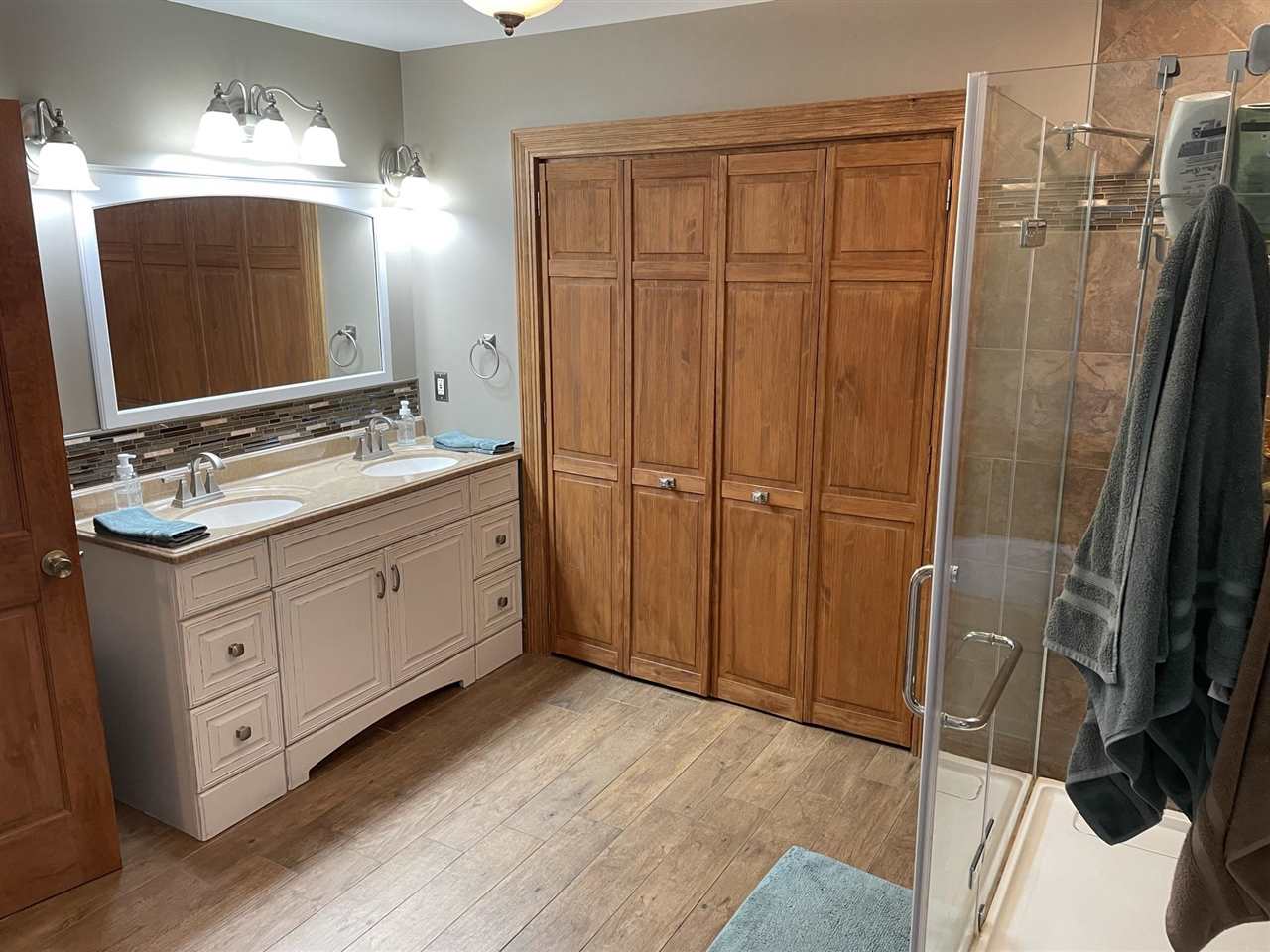 9474 Marengo Road Garden Prairie, IL 61038 - Photo 17 of 31 a bathroom with a double vanity sink a mirror and shower
