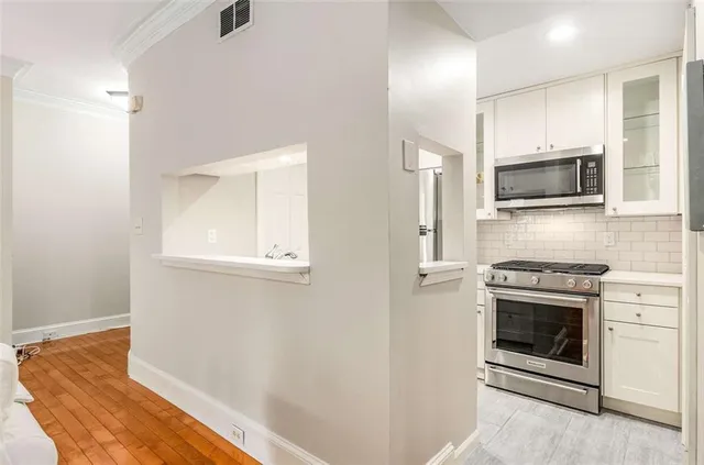 a kitchen with granite countertop a stove top oven and cabinets