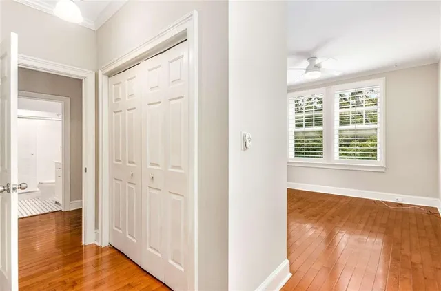 a view of a room with wooden floor and windows with curtains