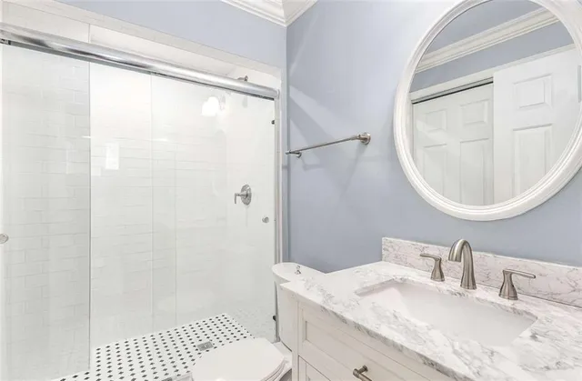 a bathroom with a granite countertop sink mirror vanity and a toilet