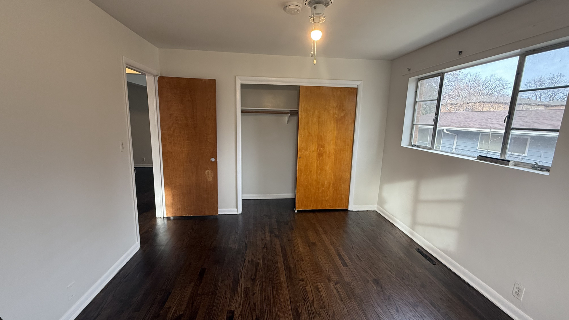1014 Edwards Street, Unit 2 Waukegan, IL 60085 - Photo 7 of 9 a view of an empty room with wooden floor and a window