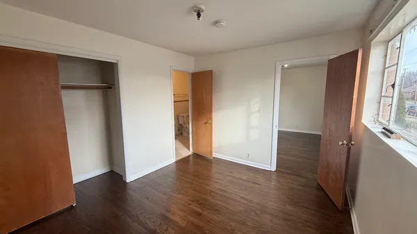 an empty room with wooden floor and a window