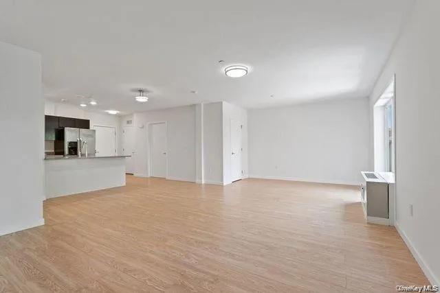 a view of an empty room with a kitchen