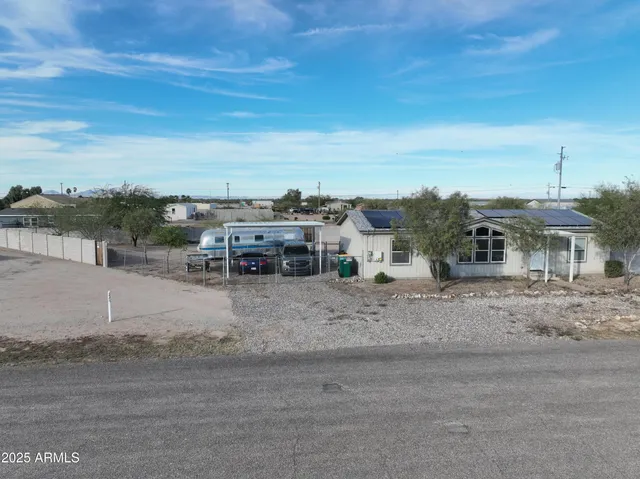 a view of a dry yard with wooden fence