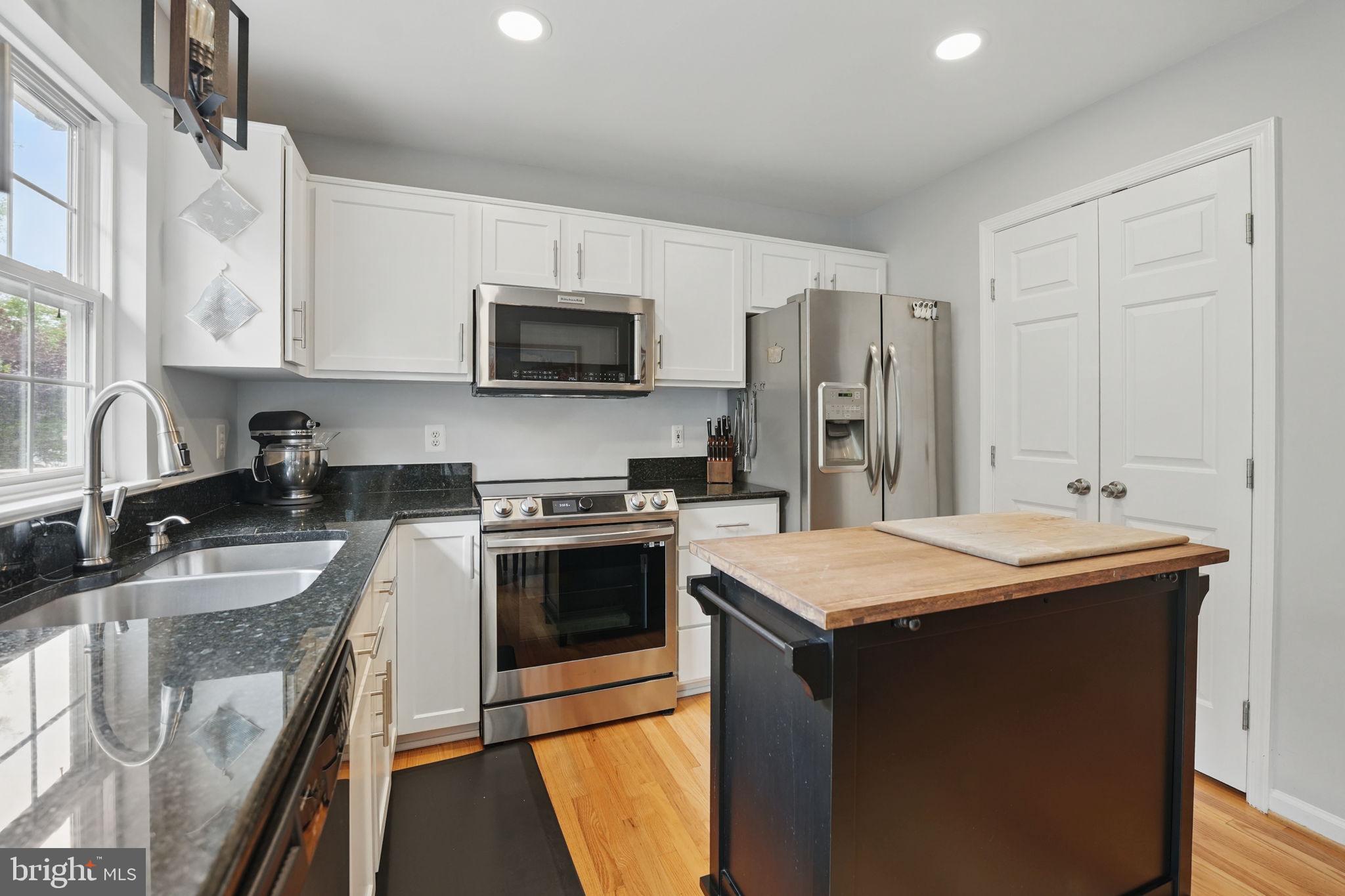 6383 Michael Robert Drive Springfield, VA 22150 - Photo 8 of 29 a kitchen with stainless steel appliances granite countertop a sink stove microwave and refrigerator