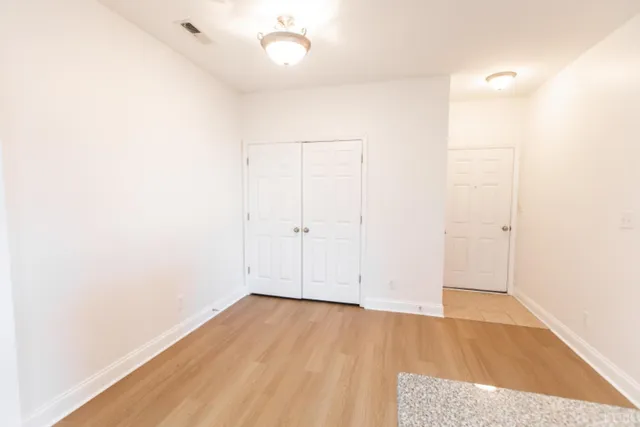 an empty room with wooden floor and white walls
