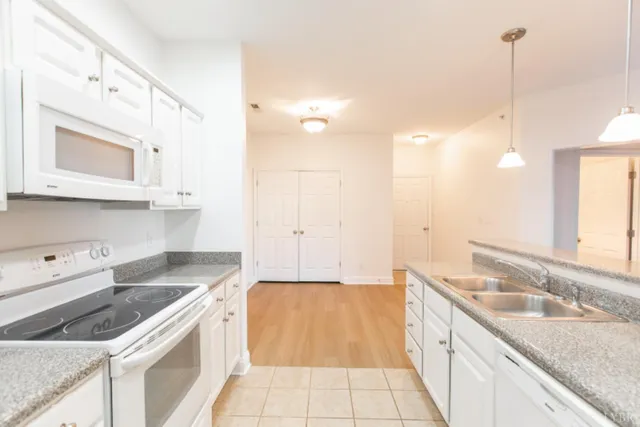 a kitchen with granite countertop a sink a stove and cabinets