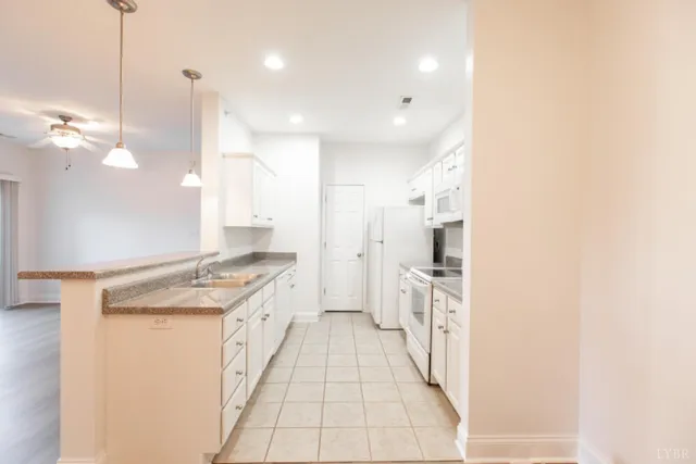 a large white kitchen with a stove a sink and a refrigerator