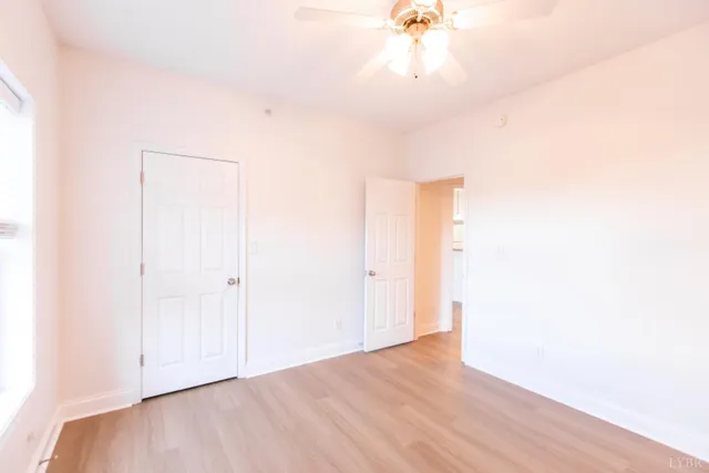 a view of an empty room with a chandelier fan