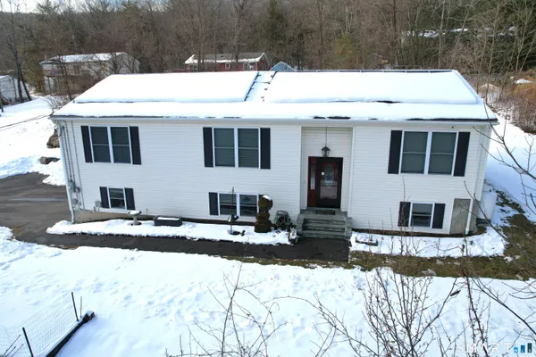 a view of a house with snow on the road