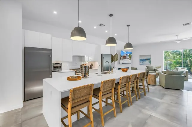 a living room with furniture kitchen view and a chandelier