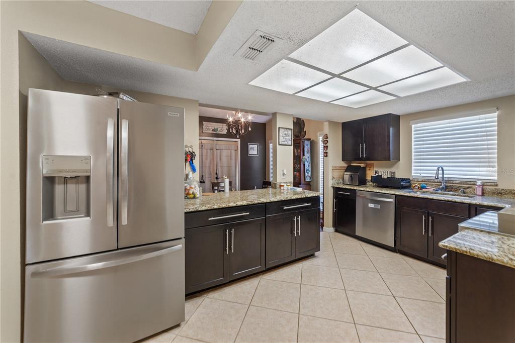 8715 Huntsman Lane Port Richey, FL 34668 - Photo 13 of 54 a kitchen with granite countertop stainless steel appliances and wooden cabinets