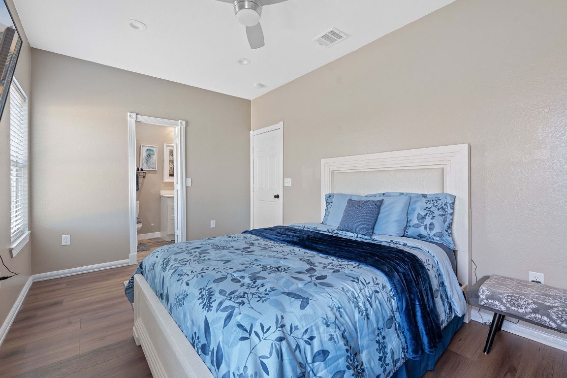 169 Ridgetop Road Buda, TX 78610 - Photo 15 of 40 a bedroom with a large bed and a chandelier