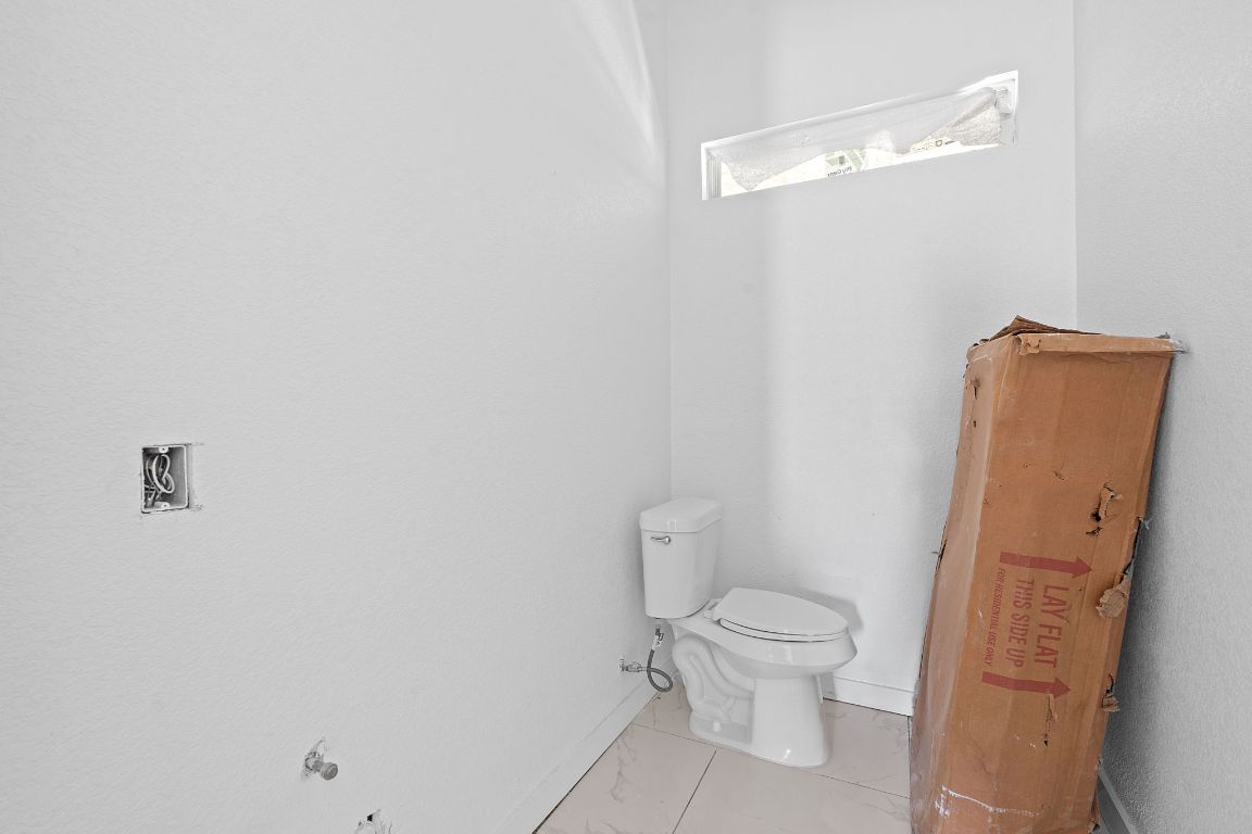 169 Ridgetop Road Buda, TX 78610 - Photo 35 of 40 a white toilet sitting next to a bathroom sink