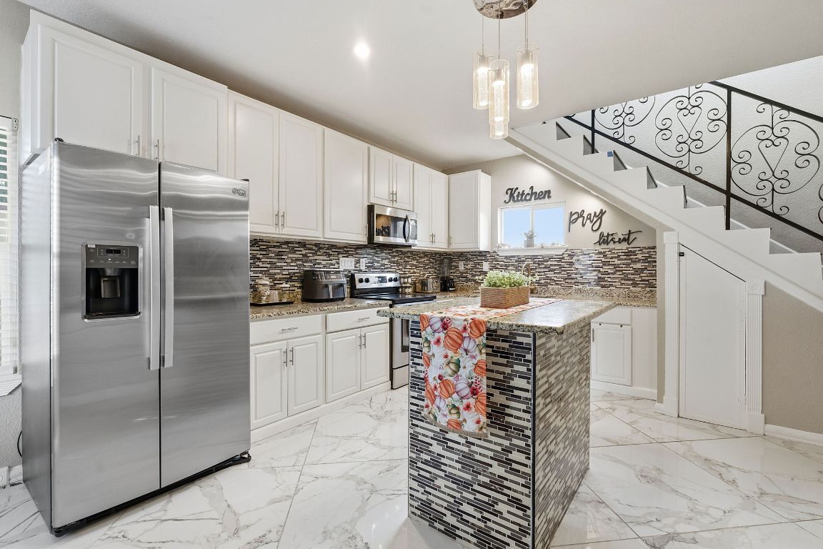 169 Ridgetop Road Buda, TX 78610 - Photo 5 of 40 a kitchen with stainless steel appliances granite countertop a refrigerator a stove and a sink