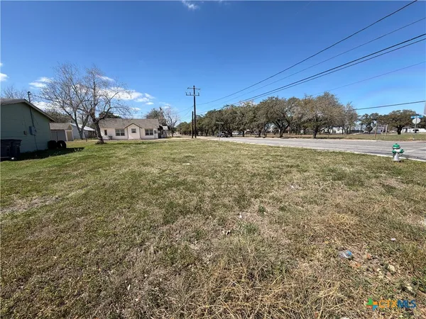 a view of a field of grass and trees