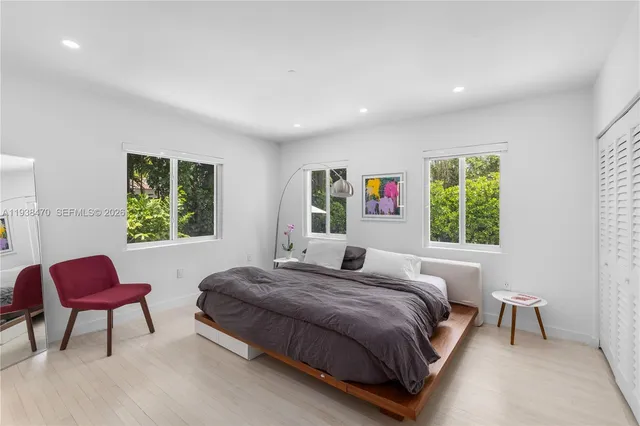 a bedroom with a bed chair and a window