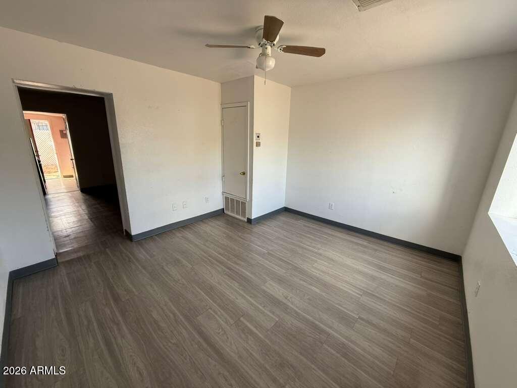 396 North E Avenue Douglas, AZ 85607 - Photo 2 of 14 an empty room with wooden floor and windows