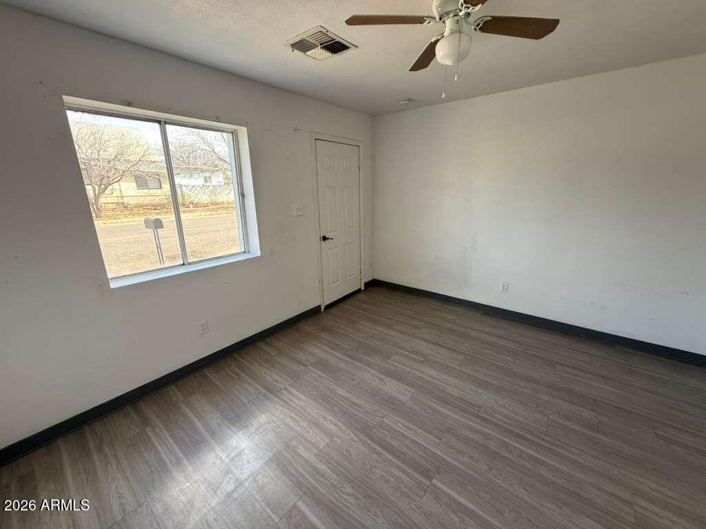 396 North E Avenue Douglas, AZ 85607 - Photo 3 of 14 an empty room with wooden floor fan and windows