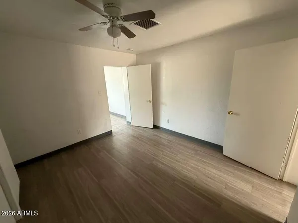 a view of a room with wooden floor and white walls