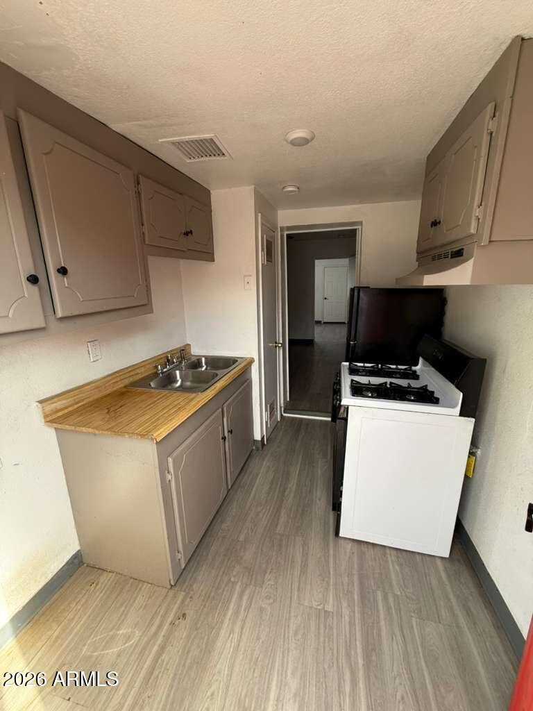 396 North E Avenue Douglas, AZ 85607 - Photo 7 of 14 a kitchen with wooden cabinets and white appliances