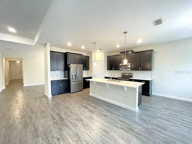 a large kitchen with a center island stainless steel appliances and cabinets