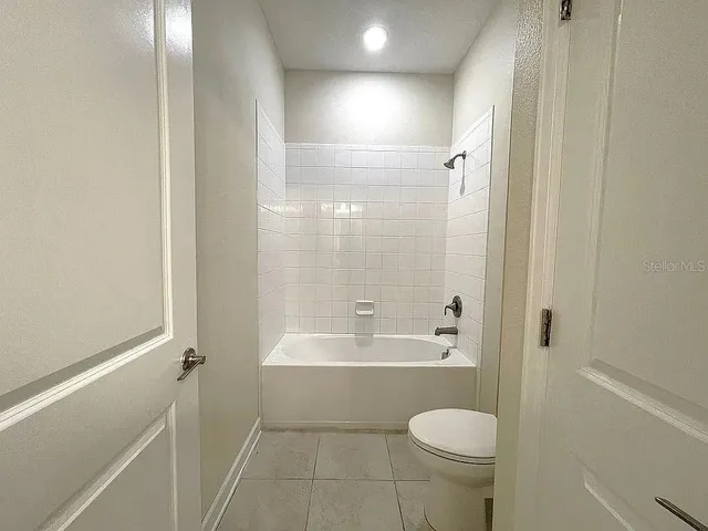 a bathroom with a granite countertop toilet a sink and bathtub