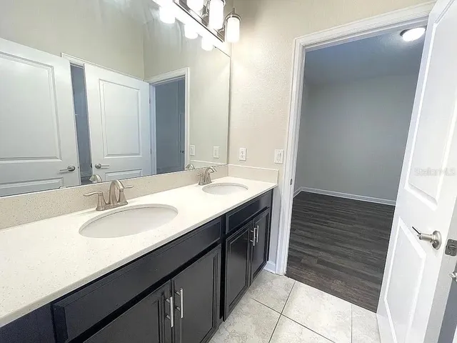 a bathroom with a double vanity sink and a mirror
