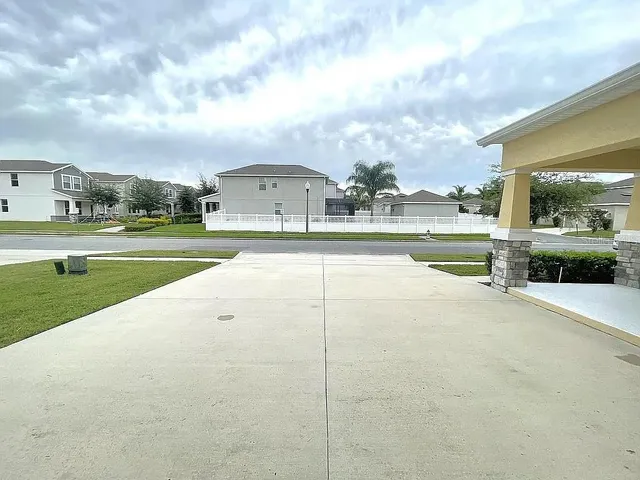 a view of a house with a yard and a large tree