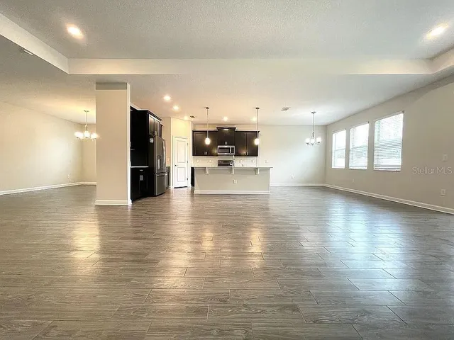 a view of a living room and kitchen with furniture and floor to ceiling window