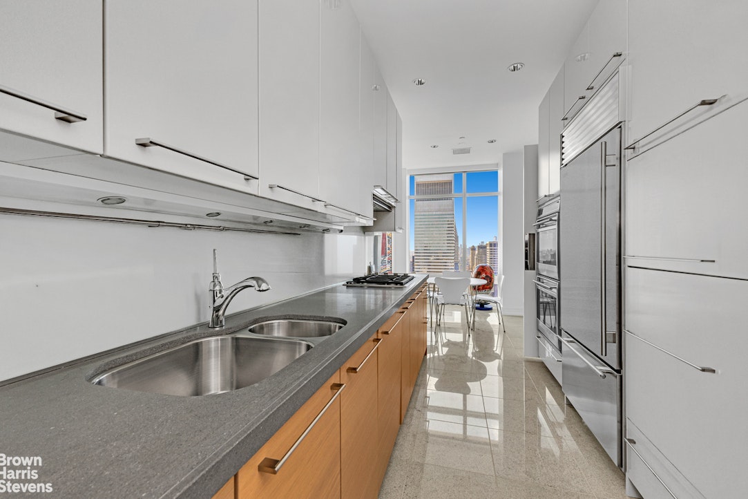 151 East 58th Street, Unit 43E Manhattan, NY 10022 - Photo 10 of 50 a kitchen with a sink and refrigerator