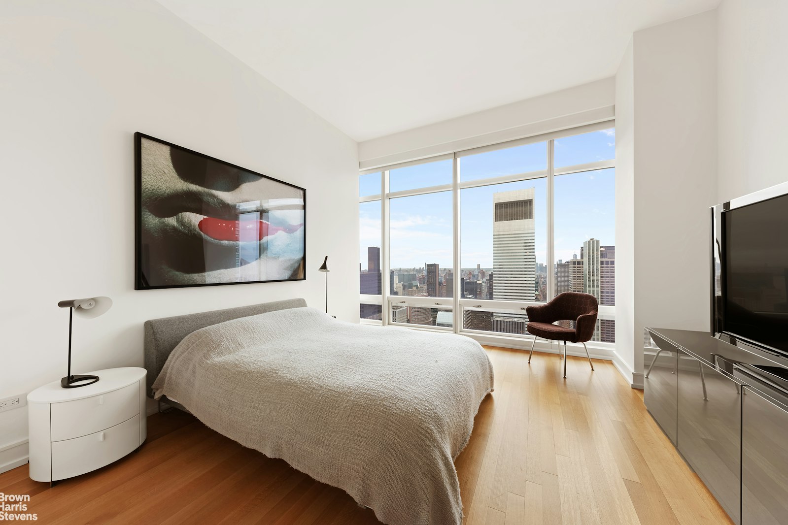 151 East 58th Street, Unit 43E Manhattan, NY 10022 - Photo 39 of 50 a bedroom with a bed and a flat screen tv